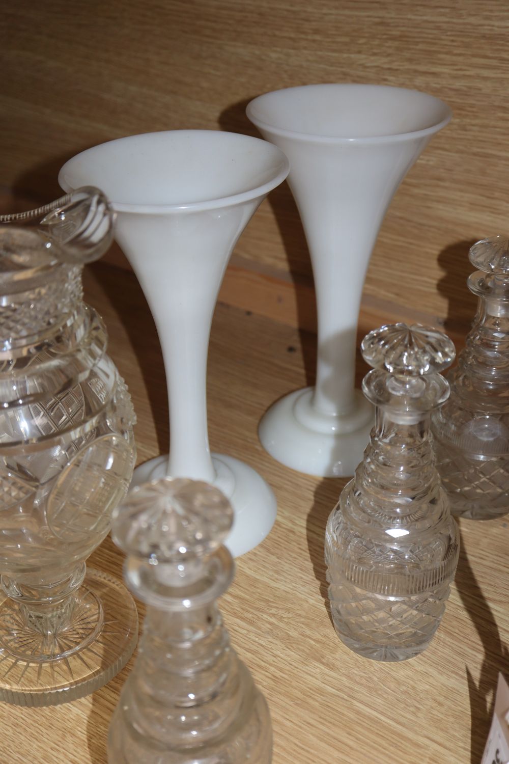 A quantity of 19th century cut glass including a set of four small decanters, together with a pair of opaque white glass vases